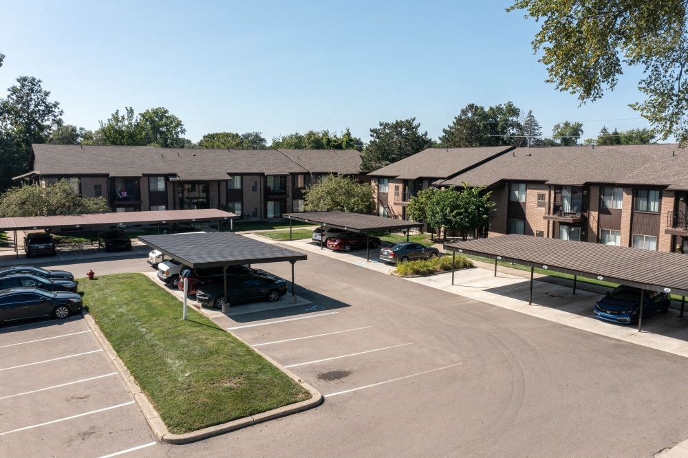 a parking lot with several apartment buildings in the background