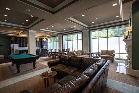 a large living room with a pool table and couches