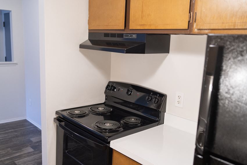 Kitchen with electric stove and black fridge Kitchen