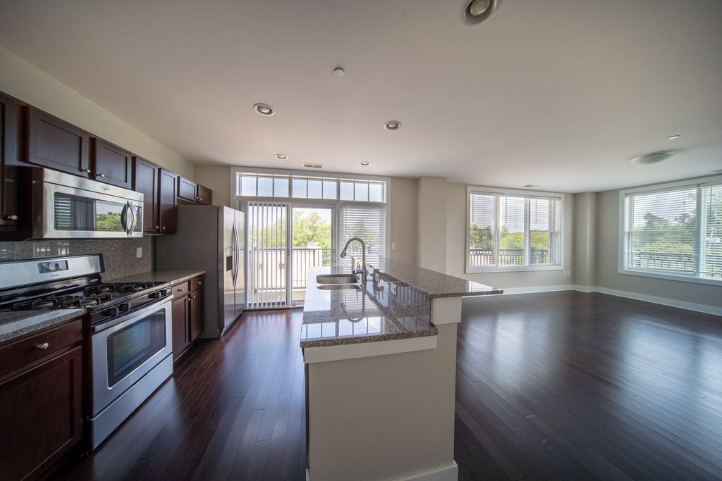 Modern kitchen with large windows, stainless steal appliances, and a large kitchen island at the Residences of Creekside.