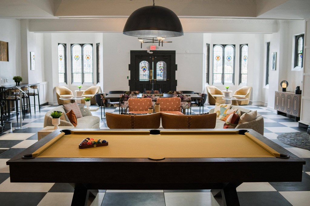 a pool table in the middle of a room with tables and chairs