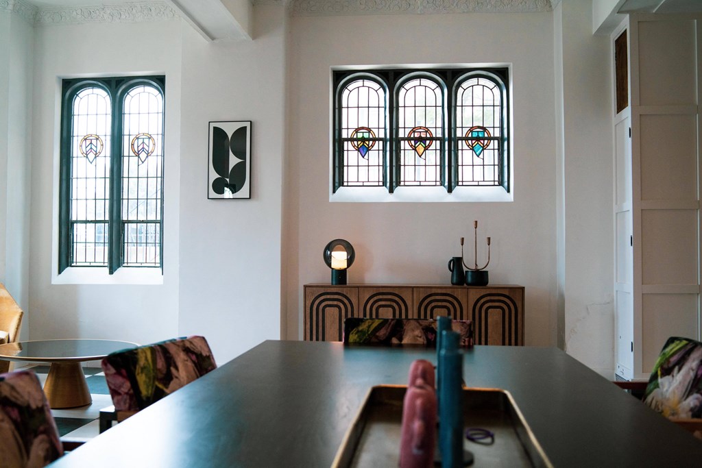 a dining room with two stained glass windows and a table