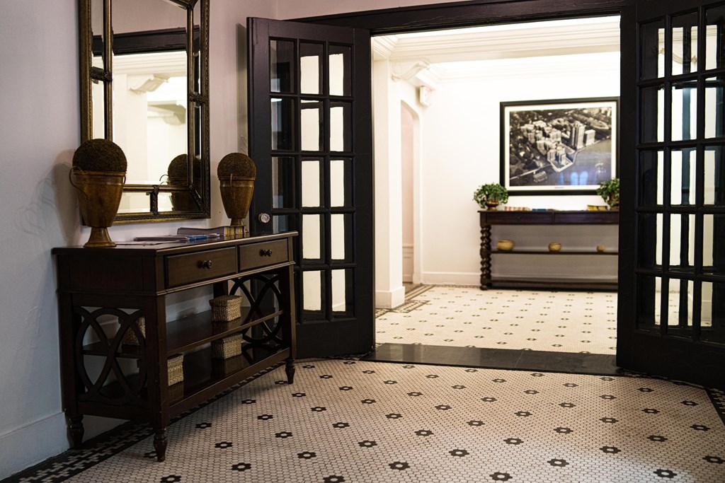 a hallway with two open doors and a dresser with a mirror