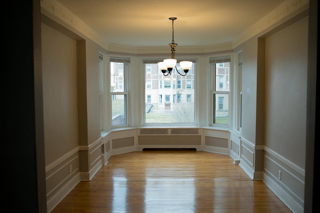 a dining room with a large window and a wooden floor