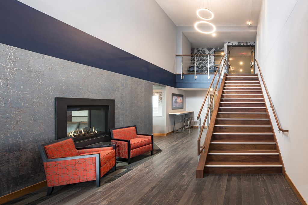 A living room with a fireplace and a staircase.