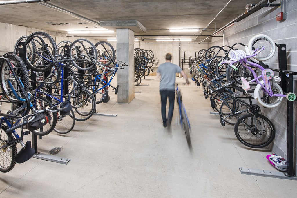 A man is walking through a bike parking area.