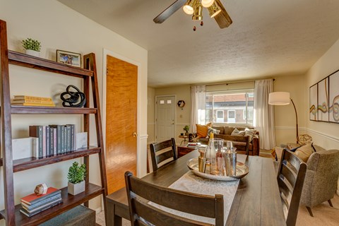 A dining room with a wooden table and chairs.