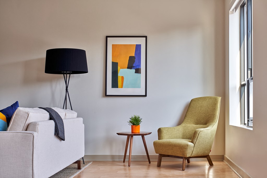 a living room with a couch chair and a small table with a plant in it