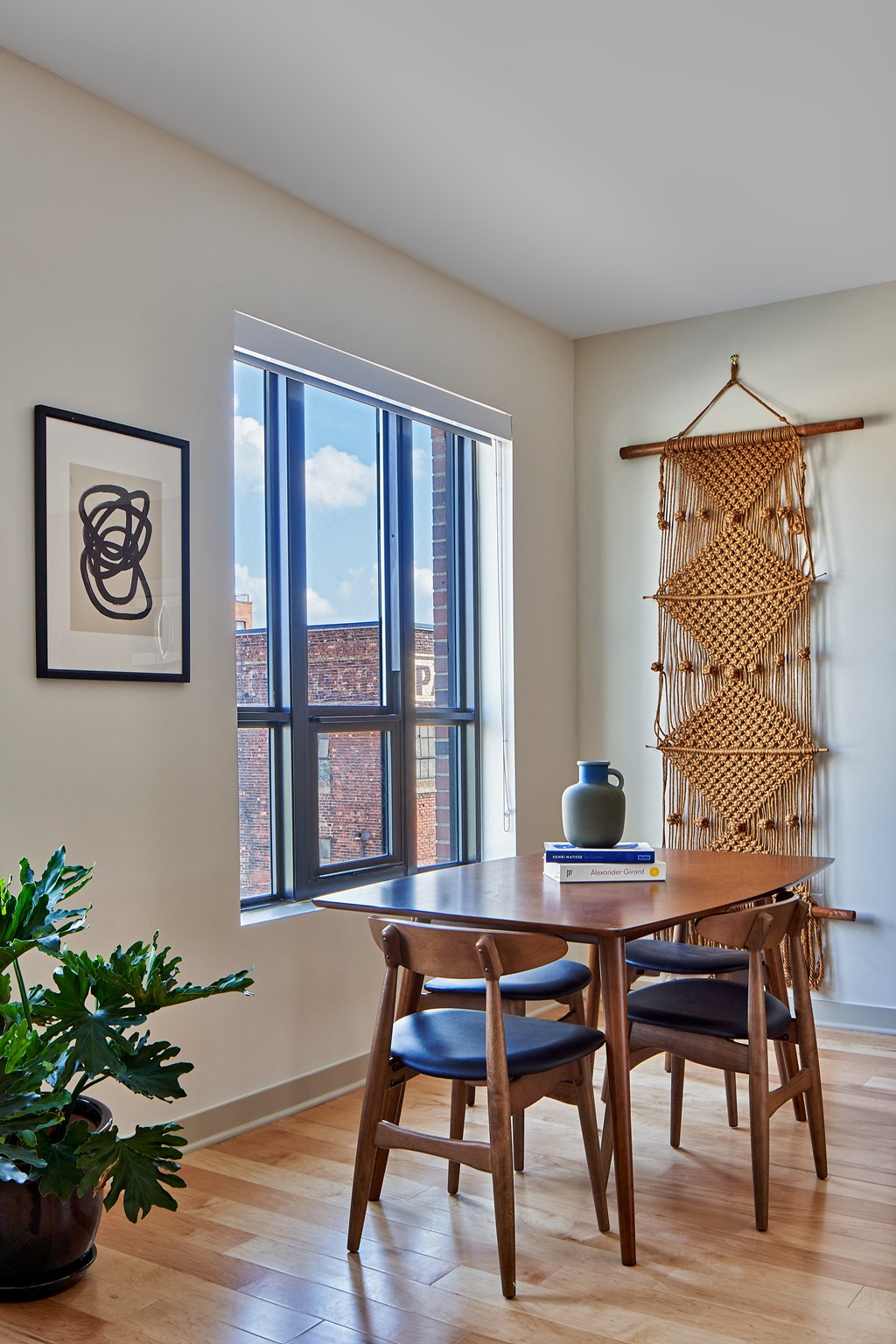 a dining room with a large window and a wooden table and chairs