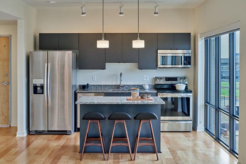 a kitchen with a large island with three stools in front of it