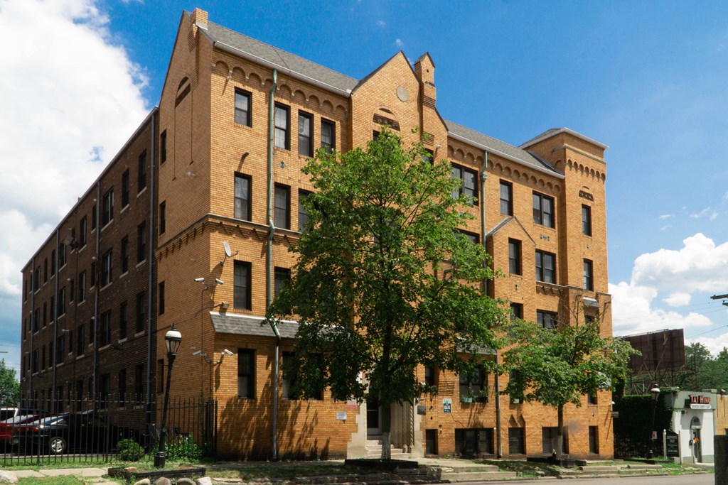a large brick building with a tree in front of it