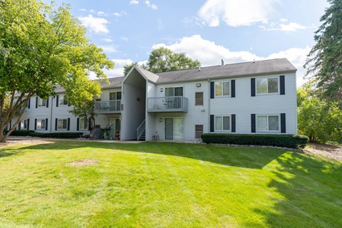 white apartment building with green grass and trees