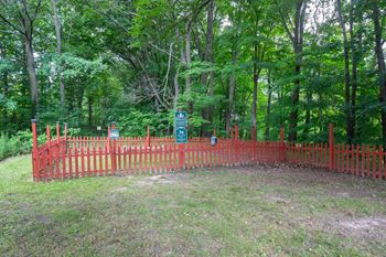 A green sign is in front of a red fence.