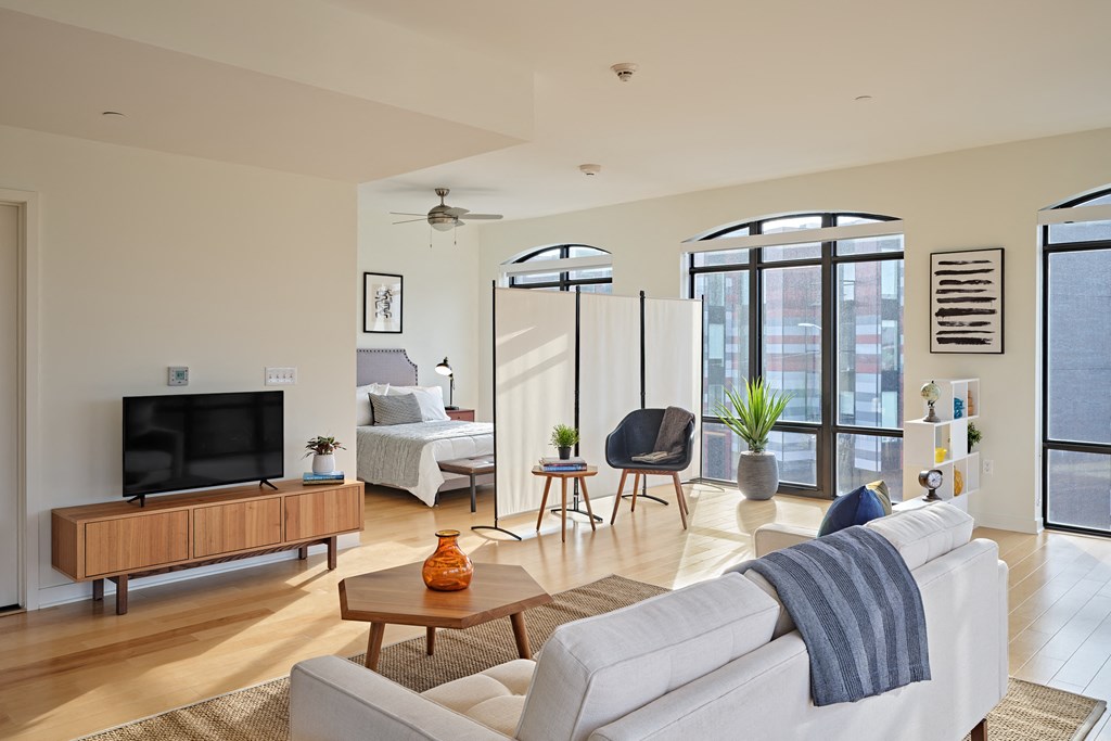 a living room with a white couch and a television