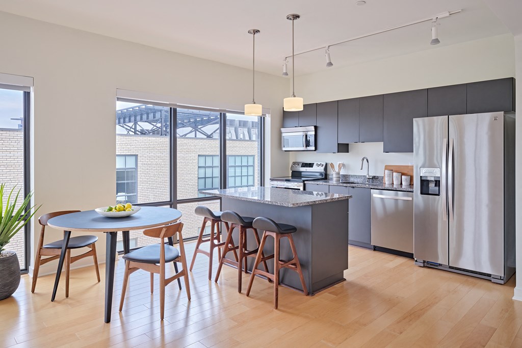 an open kitchen and dining area with stainless steel appliances and a round table