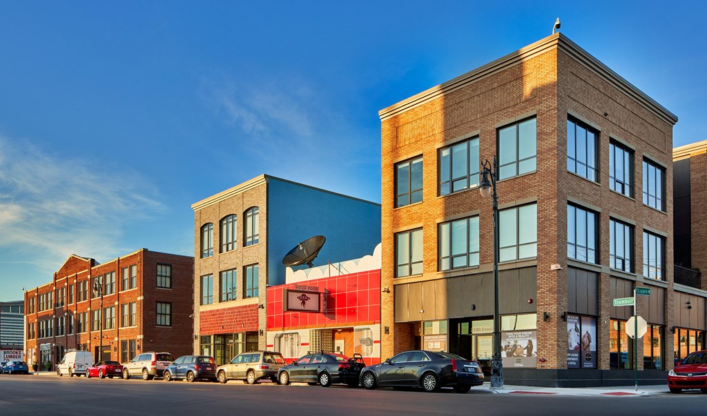 a row of buildings on a city street with a blue sky in the background