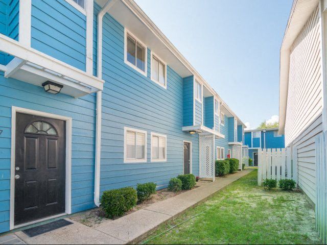 Blue exterior building with a sidewalk in front of it.