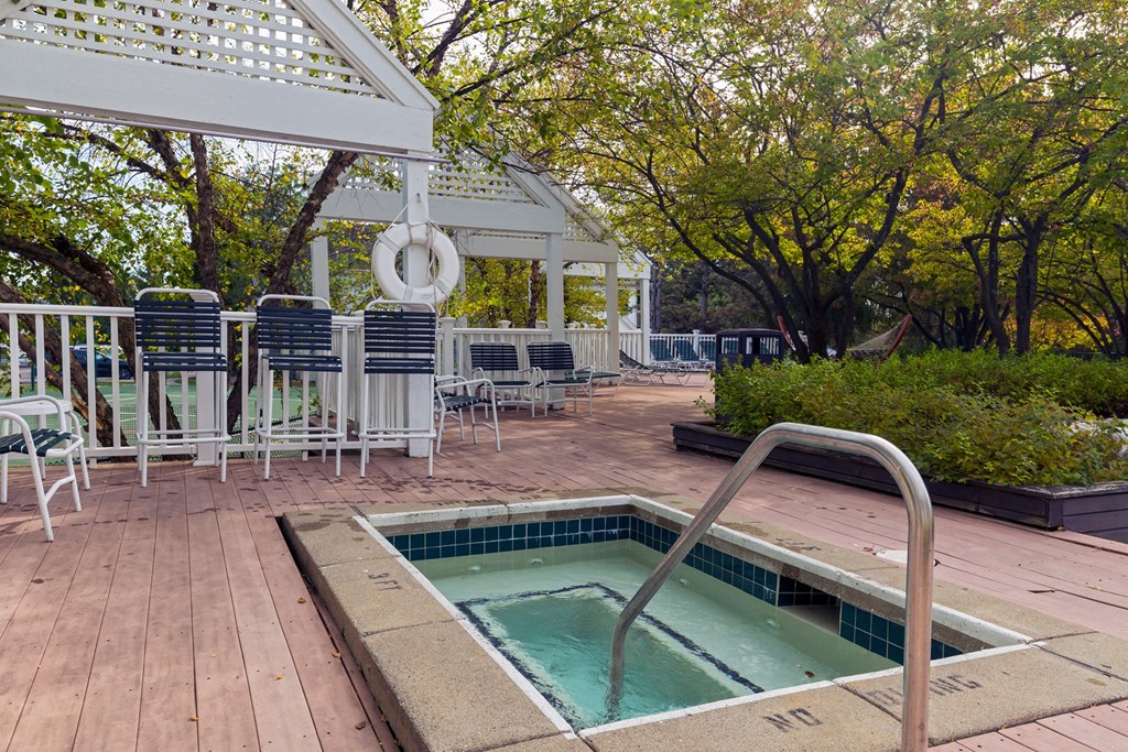 a hot tub in the middle of a deck with chairs at Village Club of Farmington Hills, Michigan