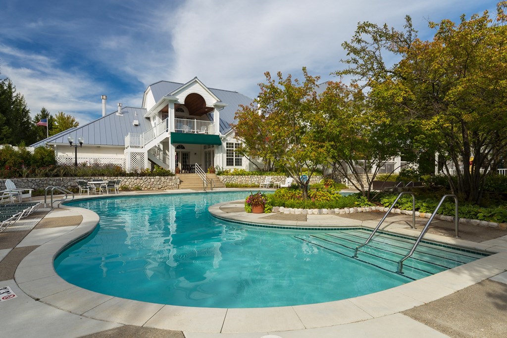 a swimming pool with a house in the background at Village Club of Farmington Hills, Farmington Hills Michigan