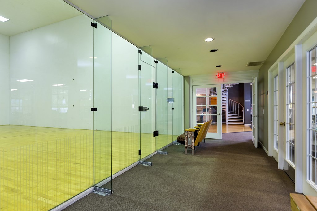 A hallway with glass walls and yellow flooring.