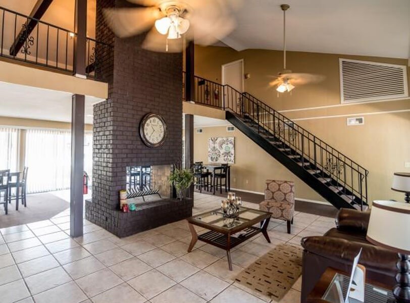 Clubhouse at Atwood Oaks. Large open room with tile floor and a large brown fireplace.