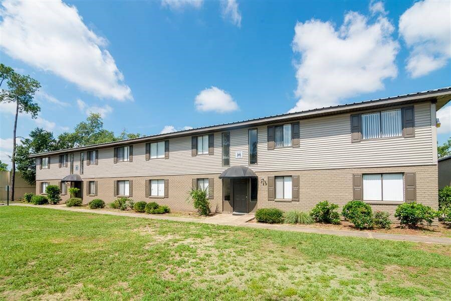 Exterior of Atwood Oaks with green grass and shrubs.
