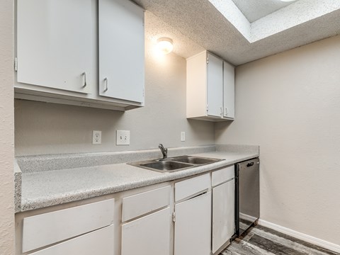 A kitchen with white cabinets and a granite countertop.