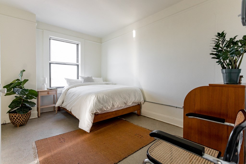 a bedroom with a bed and a desk with a chair