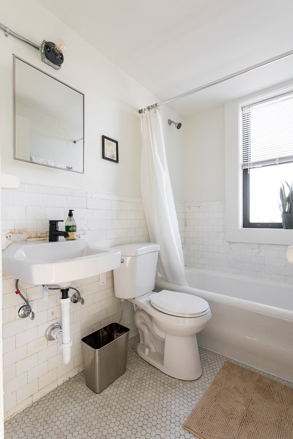 a small bathroom with a sink toilet and bathtub
