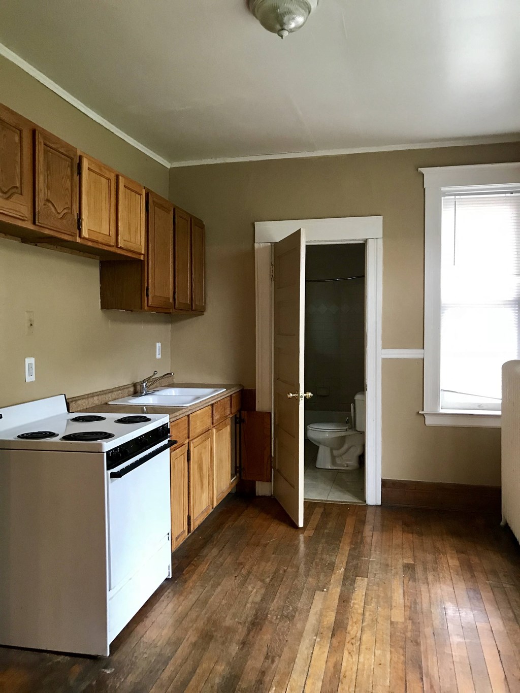 a kitchen with brown cabinets and a white stove top oven