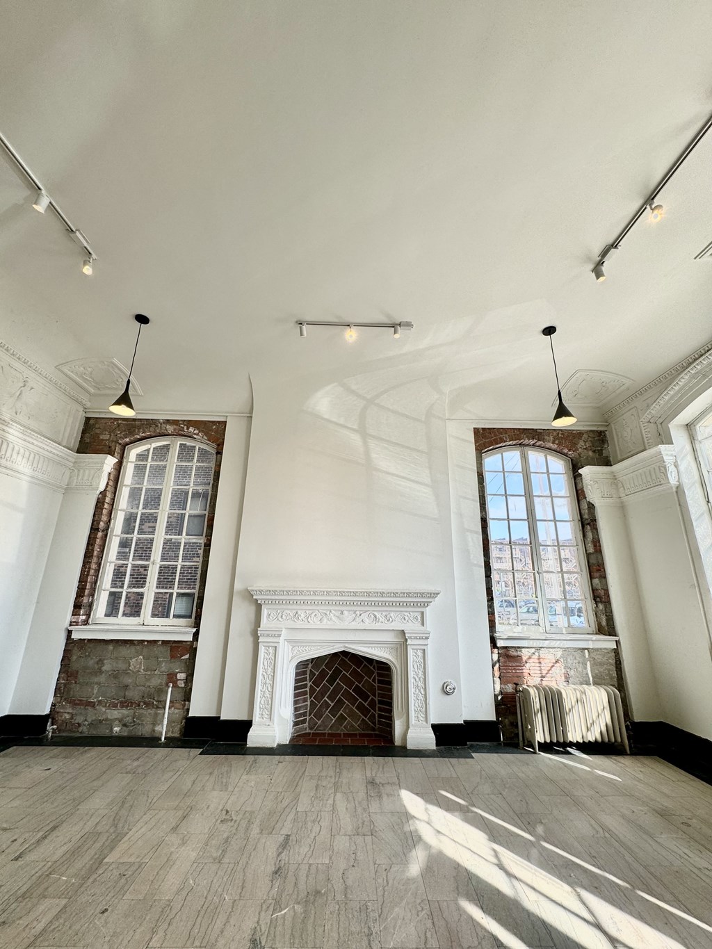 a large white room with a fireplace and two windows