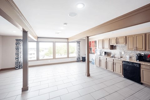 A kitchen with a black oven and white tiles.