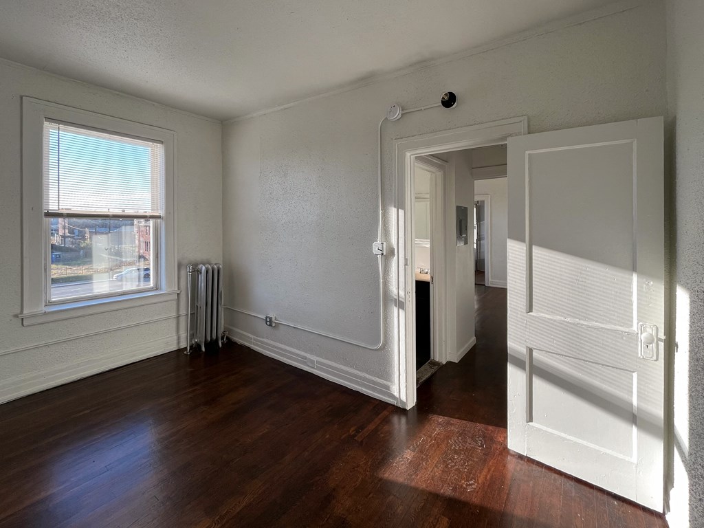 a living room with hardwood floors and a large window