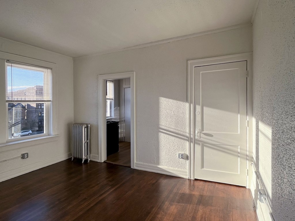 a living room with hardwood floors and white walls