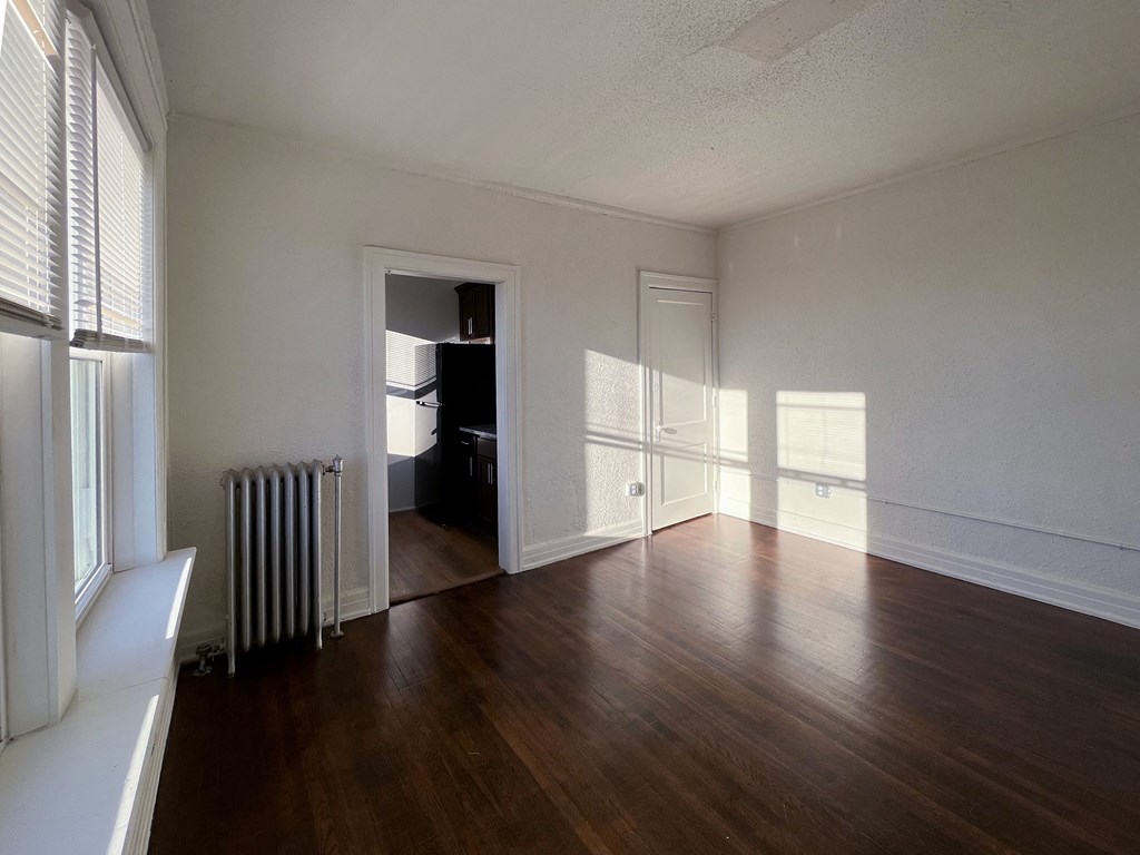 a living room with hardwood floors and white walls