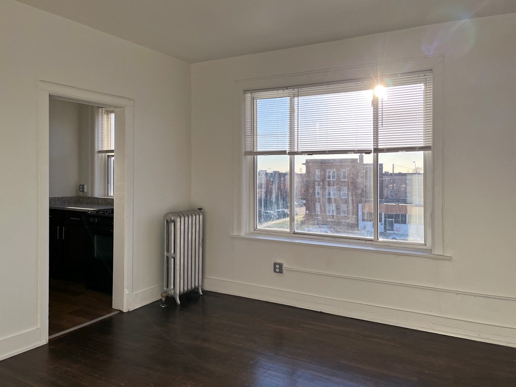an empty room with a radiator and a large window