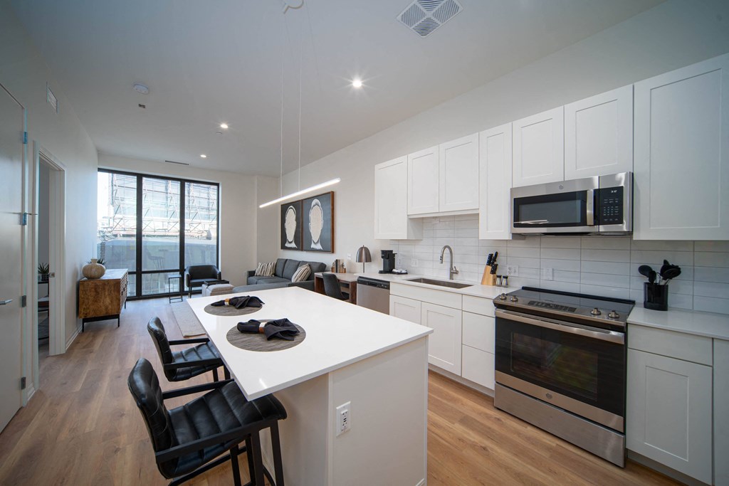 an open kitchen and living room with a white counter top