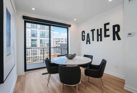 a dining room with a table and chairs in front of a window