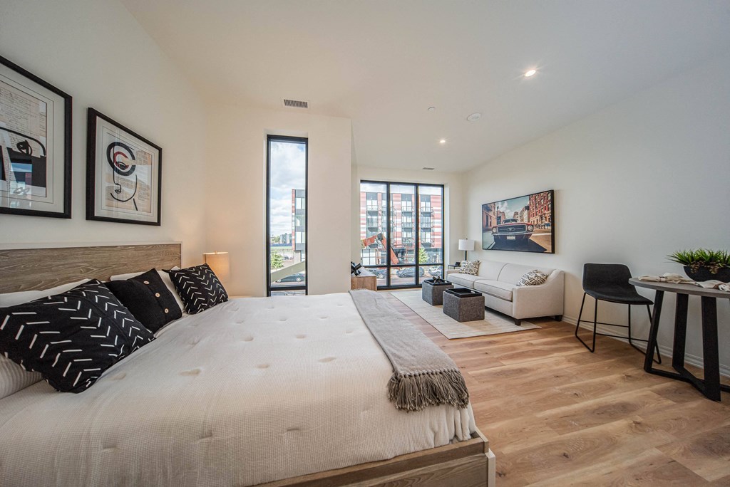 a bedroom with a bed and a couch and a living room