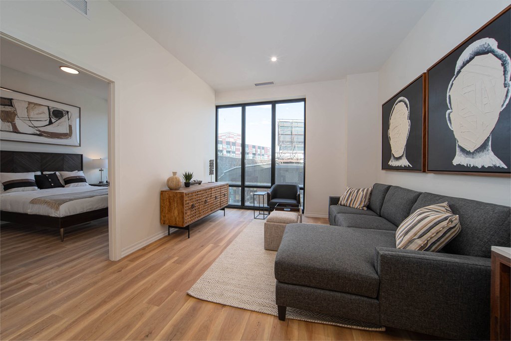 a living room with a couch and a chair and a bed