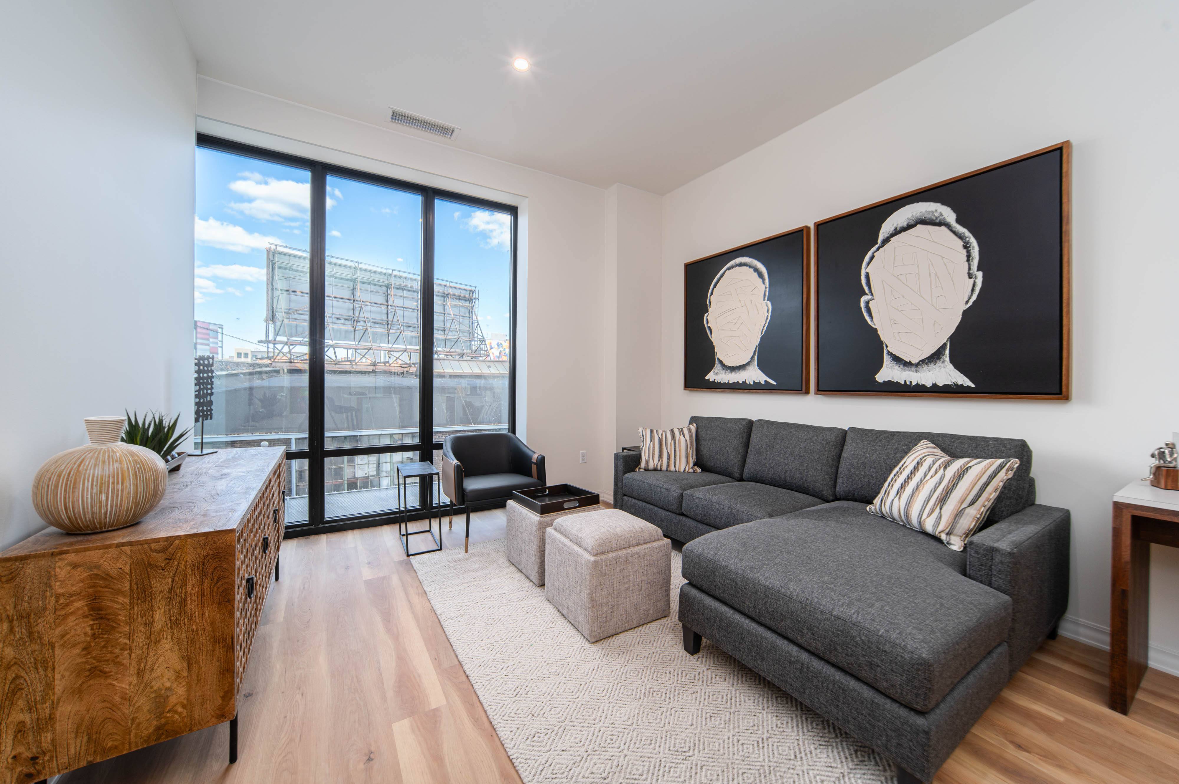 a living room with a gray couch and a large window