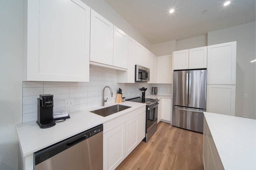 a kitchen with white cabinets and stainless steel appliances