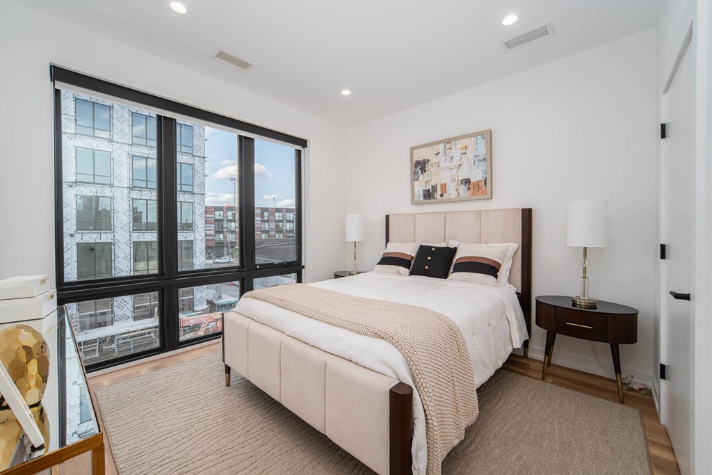 a bedroom with a large bed and a large window