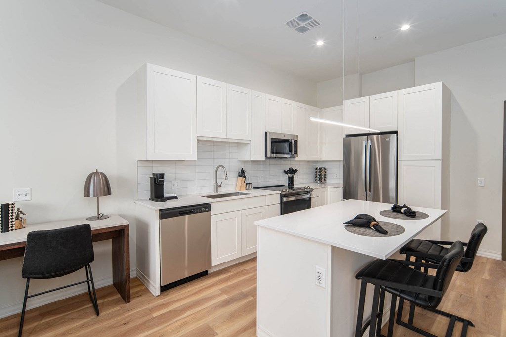 a kitchen with white cabinets and a white counter top