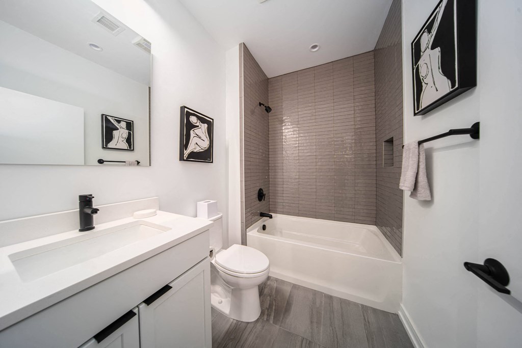 a bathroom with a toilet and a tub and a sink