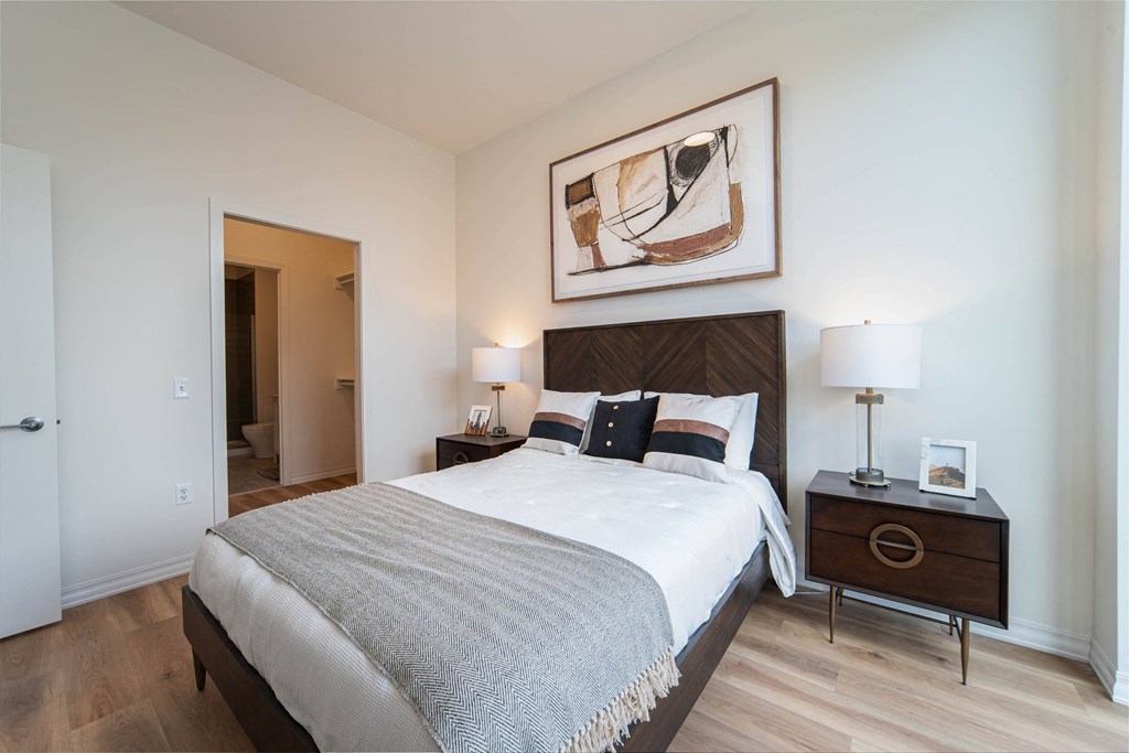 a bedroom with a bed and a painting on the wall