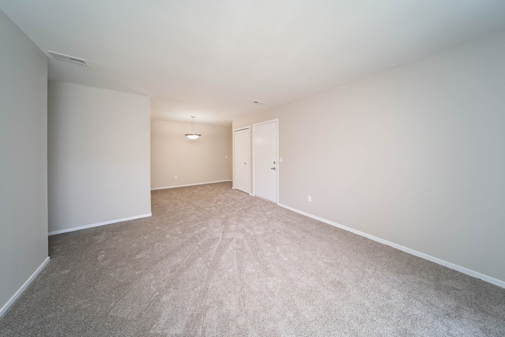 open room with carpet and white walls