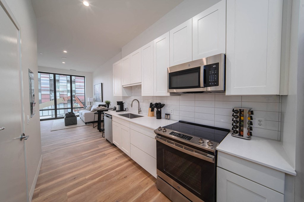 a kitchen with white cabinets and a stove and a microwave