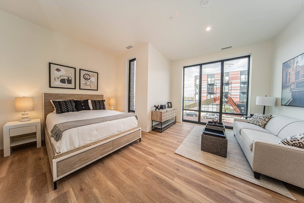 a bedroom with a bed and a couch and a large window