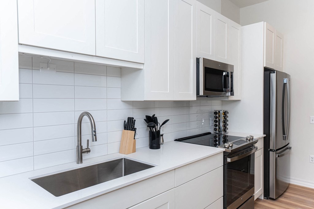 a kitchen with white cabinets and a sink and a microwave